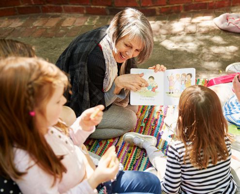Woman reading with children in the courtyard